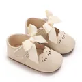 Primer plano de zapatos de princesa para bebé crema con lazos grandes y suela blanda - Albaricoque
