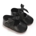 Primer plano de zapatos de princesa para bebé negros con lazos grandes y calados florales - Negro