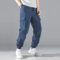 Detailweergave van de blauwe cargo herenbroek met multi-pocket design en elastische manchetten. - Marineblauw
