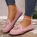 Detail van roze suède damesloafers met kwastjes en witte contrasterende stiksels - 36 / Roze