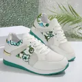 Detailopname van witte ademende mesh sneakers met gebloemd borduurwerk - Groen