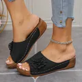 Close-up of black women's wedge sandals with decorative flower and perforated upper. - 36 / Black