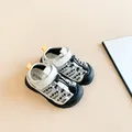 Detailopname van sportieve kindersandalen met bloemenpatroon en gesloten neus - Zwart