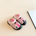Close-up van roze sport sandalen voor kinderen met bloemen bandjes en beschermende neus - Roze
