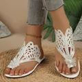 Detailed view of white flat sandals featuring sparkling rhinestones and a butterfly accent. - Off White