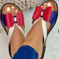 Detailopname van de rode strik en kruisbanden op dames platte sandalen - Rood