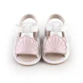Detail view of baby summer sandals featuring a cute pink shell design on white leather - Pink