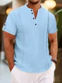 Detail of light blue textured Henley shirt with buttoned V-neck for casual summer wear - Blue