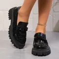 Gros plan sur des mocassins plateforme en cuir verni noir à motif croco pour femmes - 35 / Noir