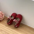 Close-up detail of red toddler princess shoes featuring elegant pearls and decorative bows - Red