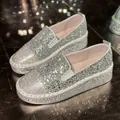 Gros plan de mocassins argentés à paillettes et strass avec semelle plateforme chic. - Argent