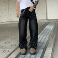 Men's black baggy straight-leg denim jeans with pearl studs and waist chain detail. - Black