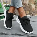 Detail view of women's black fly-knit sneakers with thick white platform sole. - 36 / Black
