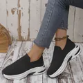 Detailed shot of women's black fly-knit slip-on sneakers with white platform soles - 36 / Black