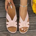 Primer plano de sandalias de cuña rosas con calados y detalles de flores - Rosa