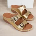 Close-up view of gold crocodile-textured wedge sandals with double adjustable buckles - Gold