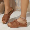 Detalle de sandalias de cuña marrones para mujer con motivos florales y costuras blancas - Tostado