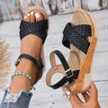 Primer plano detallado de sandalias de cuña trenzadas negras con hebilla y suela de corcho - Negro