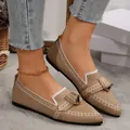 Primo piano di scarpe ballerine beige in maglia a punta con fiocco e profili bianchi. - Kaki