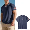 Close-up of navy linen polo shirt with American flag sleeve embroidery and flat lay view. - Navy Blue