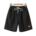 Detail van zwarte corduroy herenshort met trekkoord en een minimalistische patch - Zwart