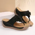 Elegant black wedge thong sandals for women featuring a large decorative flower applique - Black