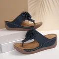 Stylish navy blue wedge thong sandals featuring a decorative flower and platform sole - Navy Blue