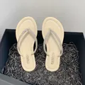 Detail of cream rhinestone flip-flops in a black gift box setting - 35 / Beige
