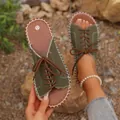 Détail de sandales pour femmes en toile vert olive avec lacets marrons et coutures blanches. - Vert