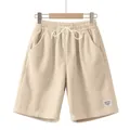 Close-up detail of men's beige corduroy drawstring shorts showing texture and tie - Apricot