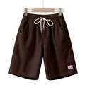 Close-up of men's brown corduroy shorts featuring a drawstring waist and side pockets - Brown