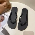 Classic black non-slip rubber flip-flops for women in a minimalist summer beach setting - S (Recommended 36-37) / Black