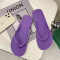 Detailed macro view of purple anti-slip flip-flops with comfortable thong straps. - Purple