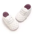 Detalle de zapatos blancos para bebé con bordado de corazones rosas y suelas suaves - Blanco
