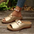 Detailed view of gold platform slides featuring a metallic buckle and a comfortable wedge sole. - 36 / Gold