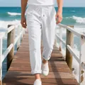 Detailed macro view of men's breathable white linen drawstring pants on a sunny beach pier - S / Bottoms / White