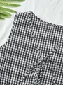 Detail van het zwart-witte ruitjesvest met striksluiting aan de voorkant en V-hals. - S / Boven- En Onderstuk / Zwart