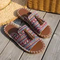 Close-up view of bohemian flat sandals with colorful woven fabric and brown tassel detail. - 36 / Red