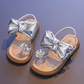 Elegant silver girl's princess sandals featuring a large metallic bow and rhinestone flower. - Silver