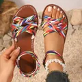 Detailansicht von flachen Boho-Sandalen mit bunten Kreuzriemen auf sandigem Boden - 36 / bunt