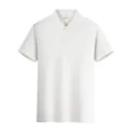 Front view detail of a classic white cotton polo shirt for men with buttoned collar - M / Tops / White