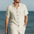 Close-up of men's casual cream linen-style short sleeve shirt and shorts on a beach. - Apricot