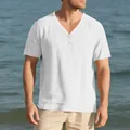Detail view of a men's white linen-like slub fabric Henley shirt in a beach setting. - S / Tops / White