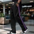 Detail view of men's black high-street sweatpants with purple side stripes and flared leg - S / Black