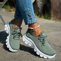 Primer plano de zapatillas de punto transpirable verdes con suela blanca gruesa en suelo. - Verde