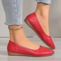 Close-up detail view of red pointed-toe flat shoes for women with textured leather finish - Burgundy