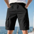Detailed view of men's black cargo shorts with utility pockets in a sunny nautical setting - S / Bottoms / Black