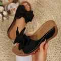 Stylish black platform sandals featuring a large bow and white contrast stitching detail - Black