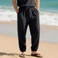 Detailed view of men's breathable black linen joggers with drawstring waist on a beach - S / Bottoms / Black