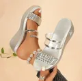 Detalle de sandalias de cuña plateadas con tiras trenzadas y elementos transparentes - Plateado